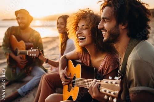 Friends playing guitar and singing on the beach at sunset