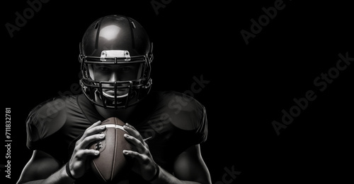 Black and white photography of an American football player holding rugby ball on a black background with copy space design