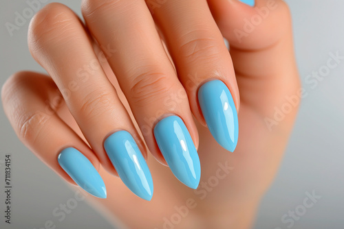 Woman hand with baby blue nail polish   manicure with gel polish at luxury beauty salon.