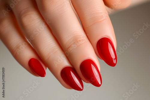 Woman hand with red nail polish manicure with gel polish at luxury beauty salon