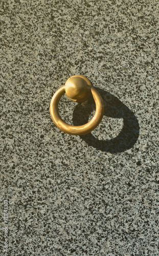 Metal ring on grave of cemetery. Rusty iron handle on granite tomb cover. An 19th century antique cemetery in Lviv photo