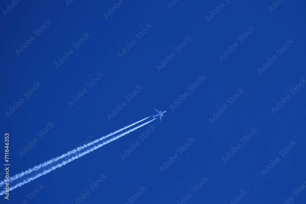 airplane trail in the clear blue sky - obrazy, fototapety, plakaty 