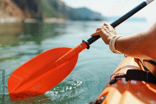 Kayak paddle sea vacation. Person paddles with orange paddle oar on kayak in sea. Leisure active lifestyle recreation activity rest tourism travel photo
