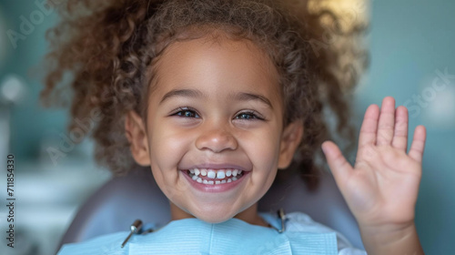 Little smiling girl sitting in dentist's chair, children's dental clinic photo