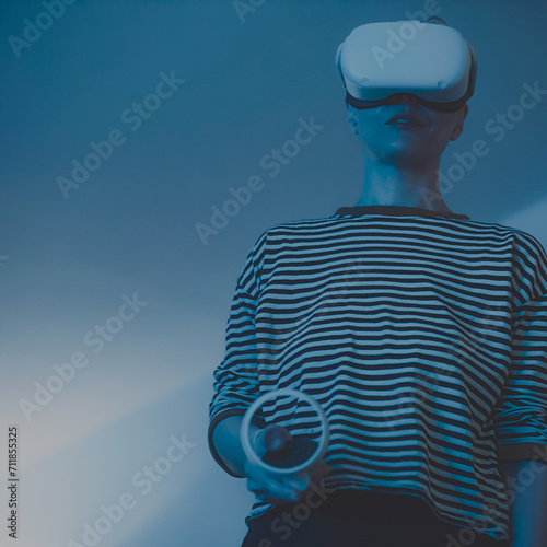 woman wearing headsets of virtual reality standing on orange background looking away