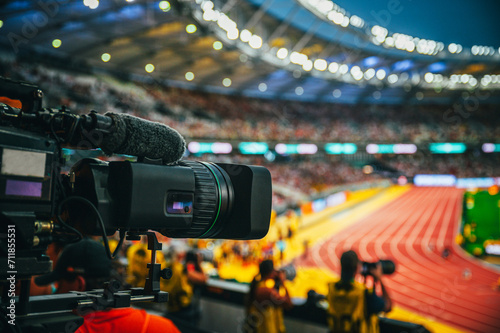 Telecast of professional athletics races. Media Coverage at Sports Event. Camera at modern stadium. Broadcasting and streaming, TV coverage in Paris. Modern athletics stadium in background