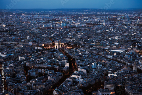 Paris city at night from above. Aerial view from Eiffel tower at blue hour. Panorama skyline after sunset. Arch of Triumph 