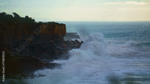 Stunning waves crashing rocky coastline at dusk. Stormy ocean making explosion