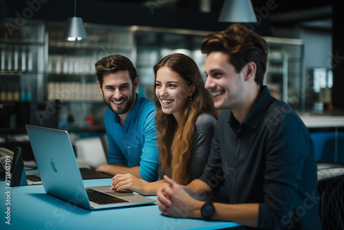 Gruppe lächelnder junger Menschen, die in einem Büro auf einen Laptop schauen, Kollegen mit Spaß und Erfolg im Büro