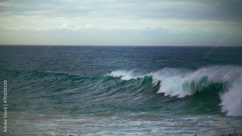 Large waves breaking surf on drone view. Stormy dark ocean rolling seashore in
