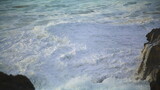 Restless sea washing rocks at morning seaside closeup. Ocean waves creating foam