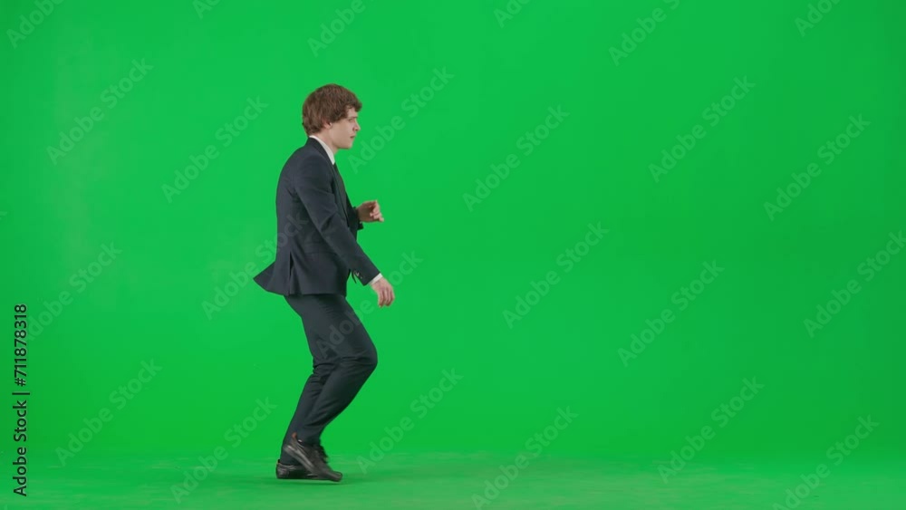 Portrait of male model in suit on chroma key green screen. Handsome young businessman in trendy suit walking spinning and dancing at camera. Portrait of male model in suit on chroma key green screen. Handsome young businessman in trendy suit walking spinning and dancing at camera.