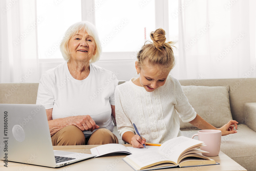 Togetherness child family education laptop grandmother selfie hugging bonding smiling sofa granddaughter