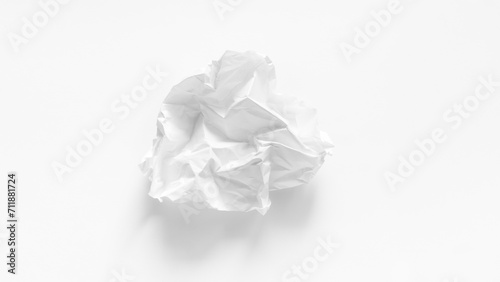 A completely crumpled sheet of paper on a white background close-up. A crumpled discarded sheet of white A4 paper. A white sheet of paper was crumpled into a ball. Paper trash close-up.