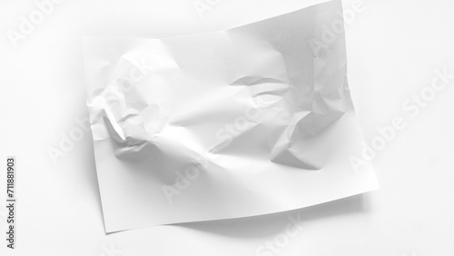The white A4 sheet is slightly wrinkled. A white crumpled sheet of paper lies in the center of a white background with copy space. Abstract white background made of paper. Mockup for inscriptions. © nieriss