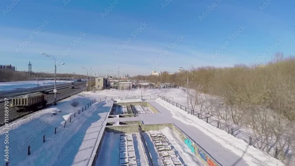 Road traffic near snow melting station at winter sunny day.