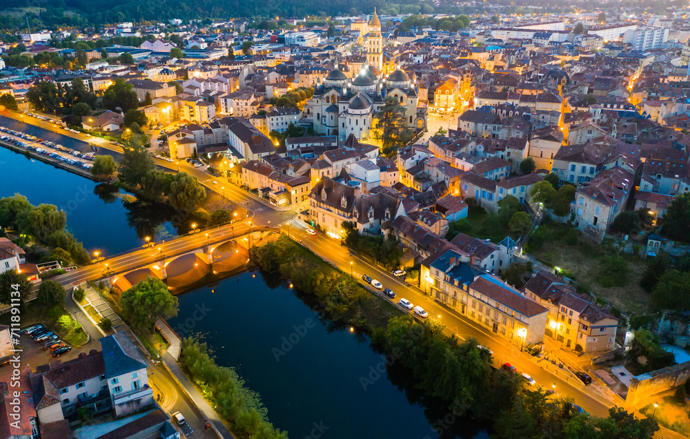 View from drone of illuminated houses and ancient Catholic Cathedral of Perigueux town at summer night, France