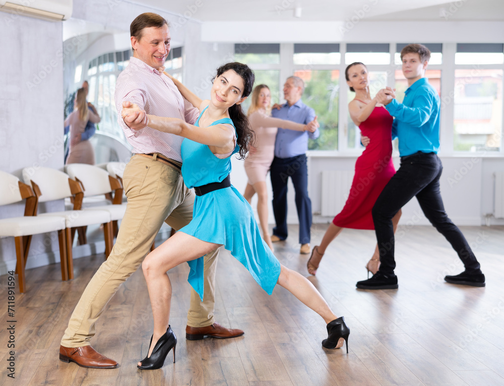 Fototapeta premium Adult man and young woman dancing in dance class