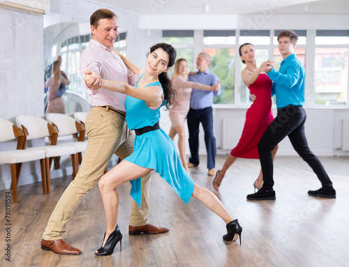 Fototapeta Naklejka Na Ścianę i Meble -  Adult man and young woman dancing in dance class