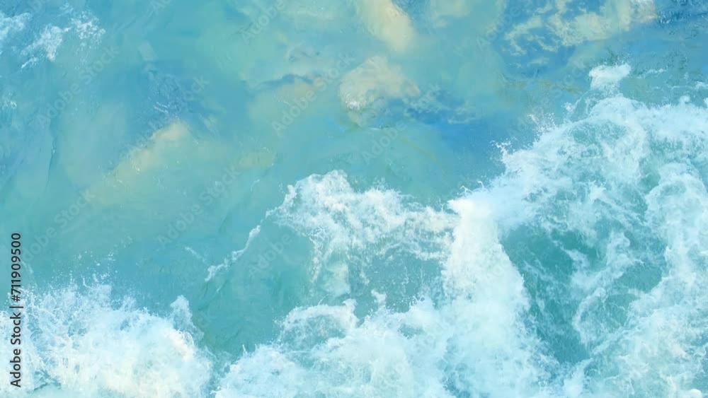 Top view of a rapidly seething stream of water. Big powerful ocean waves. White foam and water ripple. Foaming and splashing in the ocean. Strong flow of a mountain river. Translucent sea bottom Top view of a rapidly seething stream of water. Big powerful ocean waves. White foam and water ripple. Foaming and splashing in the ocean. Strong flow of a mountain river. Translucent sea bottom