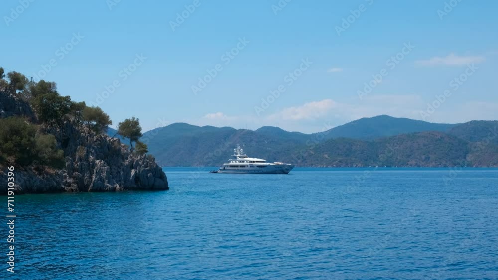 White yacht docked against hills. A nice white yacht swimming between tropical islands in the open sea in summer. White yacht docked against hills. A nice white yacht swimming between tropical islands in the open sea in summer.