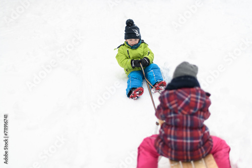Beautiful Siblings Sledding on Snow