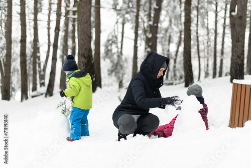 Mother With Kids Playing Outdoor in Winter Forest