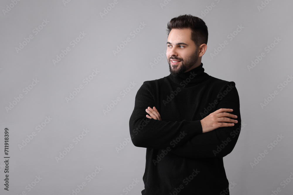 Happy man in stylish black sweater on grey background, space for text Happy man in stylish black sweater on grey background, space for text