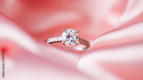 Jewellery, proposal and holiday gift, diamond engagement ring on pink silk fabric, symbol of love, romance and commitment