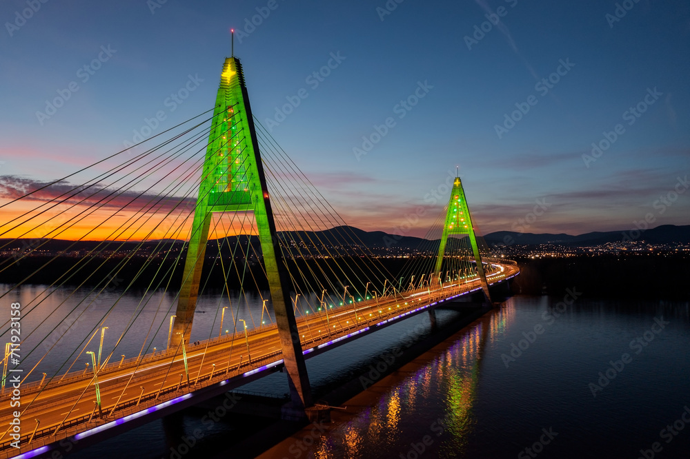 Aerial view about the illuminated Megyeri bridge in a rare christmas decorations with stunning sunset at the background.