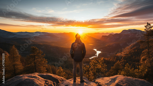 Man standing on the edge of cliff and looking at the sunrise. photo