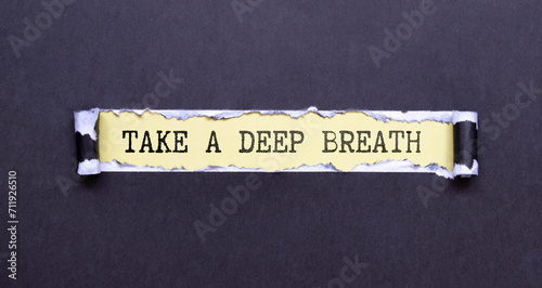 TAKE A DEEP BREATH. Text on white paper on wooden background. View from above. Marketing concept
