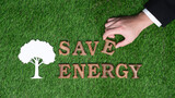 Hand arrange wooden alphabet in ECO awareness campaign on biophilia green grass background o promote eco-friendly energy and limited power consumption to reduce CO2 emission for sustainable Earth.Gyre
