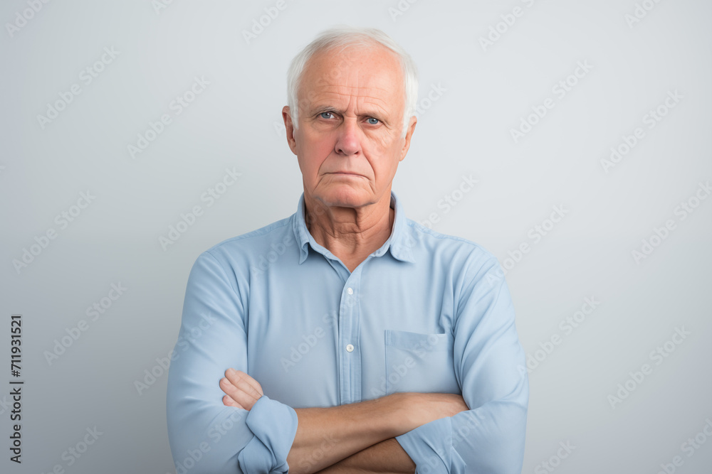 concerned looking senior man with thinning white hair downturned mouth and arms folded concerned looking senior man with thinning white hair downturned mouth and arms folded