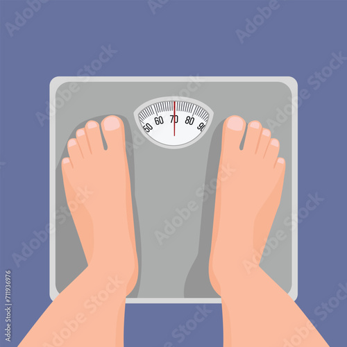 Top view of male feet standing on weighing scale