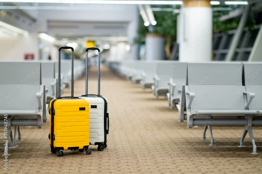 Two suitcases in an empty airport hall, traveler cases in the departure airport terminal waiting for the area, vacation concept, blank space for text message or design Two suitcases in an empty airport hall, traveler cases in the departure airport terminal waiting for the area, vacation concept, blank space for text message or design