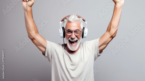 Joyful senior men in wireless headphones and enjoy music, having fun, listening to music, raising his arm, dancing to favorite song, enjoying cool soundtrack, happy life,