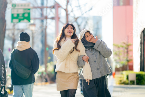 woman girl tourist Two Asian friends but different religions  one of whom is a Muslim girl. Walking tour of the city  city view  traveling in Japan. with fun She is traveling in the city area.