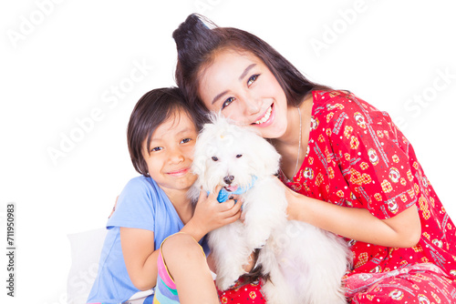 Cheerful young woman and her daughter holding a maltese dog in the studiio