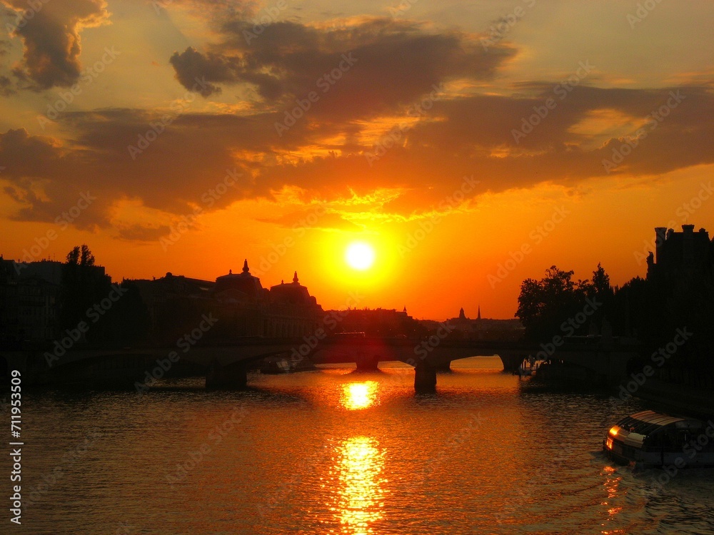 Sunset and Paris cityscape silhouette reflecting on water of Seine river in Paris, France