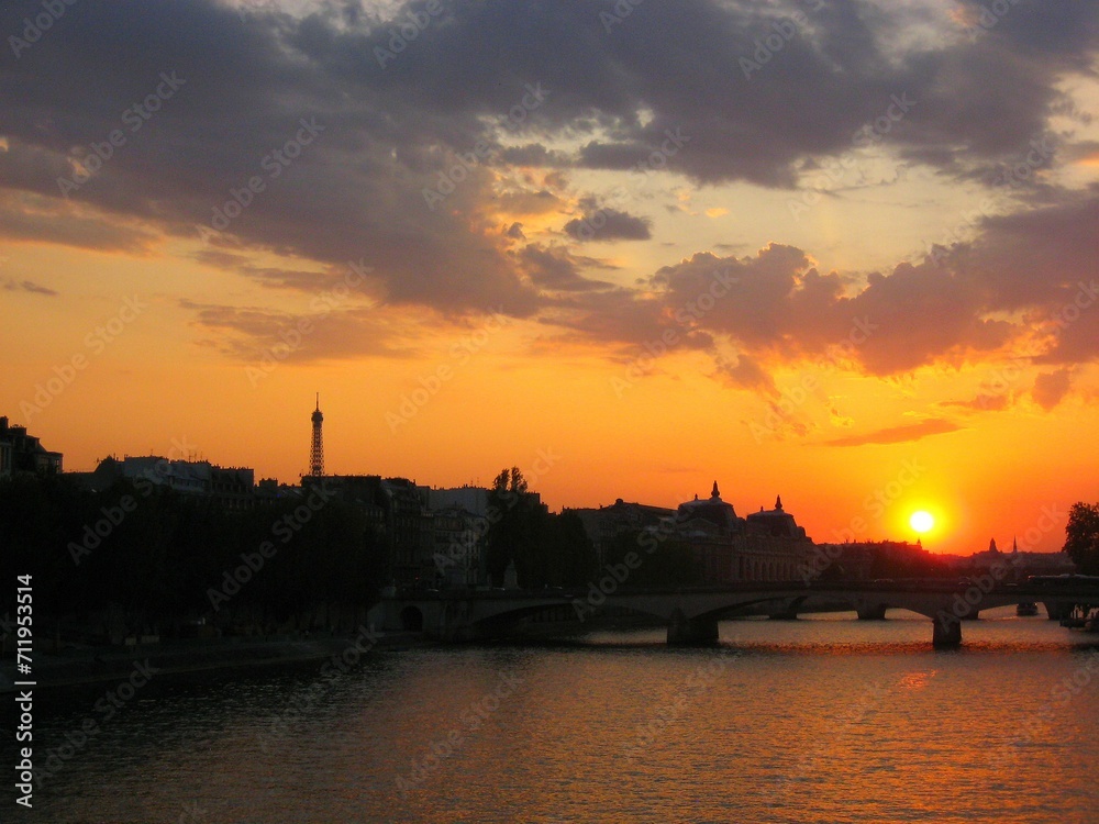 Sunset, Eiffel tower and Paris cityscape silhouette reflecting on water of Seine river in Paris, France