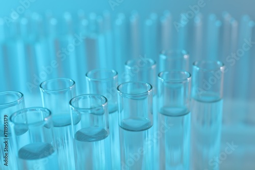 Laboratory analysis. Many glass test tubes on light blue background, closeup