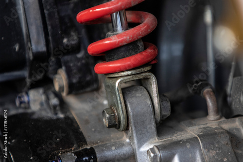 Close-up of a red shock absorber in a motorcycle service