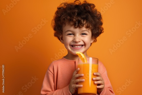 Child in orange shirt with orange juice and orange slice