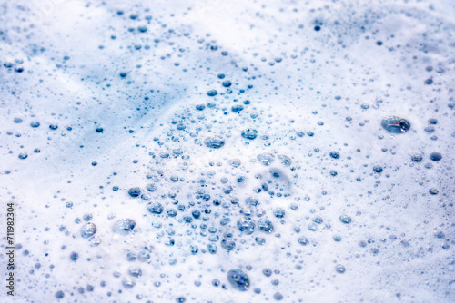 Cleaning sponge in foam of dishwashing liquid. Washing dishes concept photo