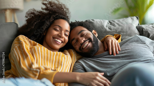 Happy couple lying on sofa together and relaxing at home photo