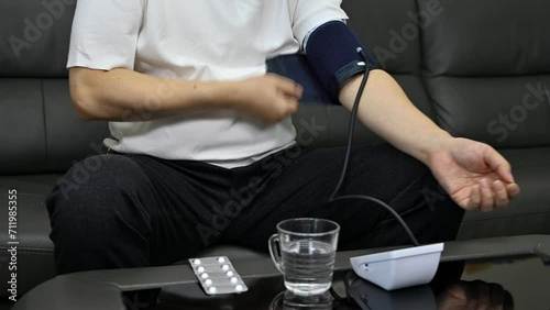 Middle-aged man using blood pressure monitor