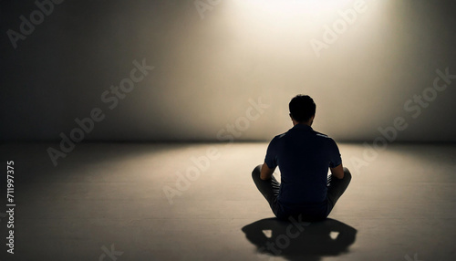 Solitary figure sits in shadow, embodying the silent struggle of mental health, conveying the weight of depression, anxiety, and bipolar disorder