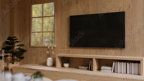 A TV monitor on a wooden wall above a wooden cabinet in a modern, expensively furnished living room.