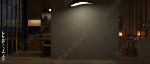 Interior design of a modern, luxury dark spacious living room at night with an empty black wall.